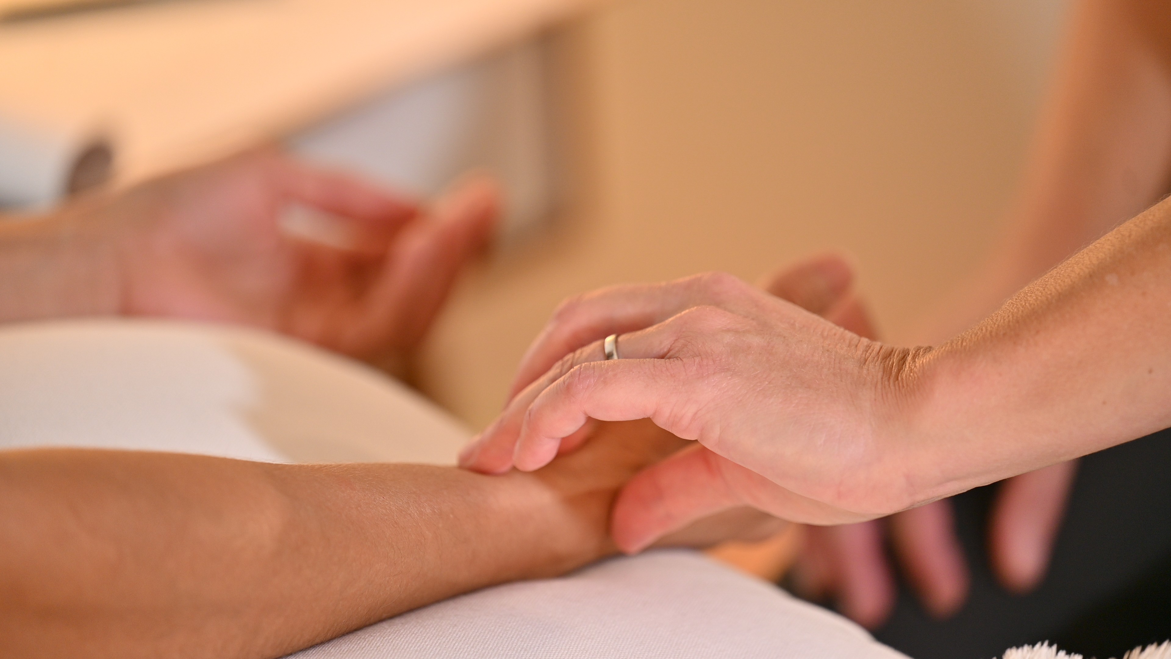 Person receiving a hand massage or therapy, with another person's hands on their arm.