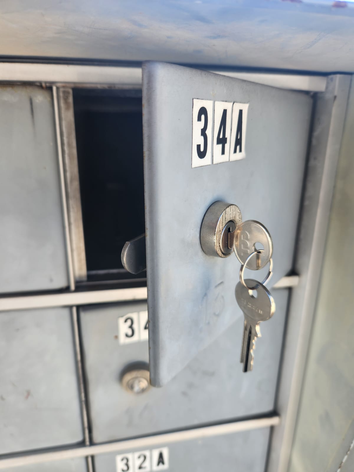 Locker with a key inserted in the lock, labeled 34A, with other lockers visible in the background.