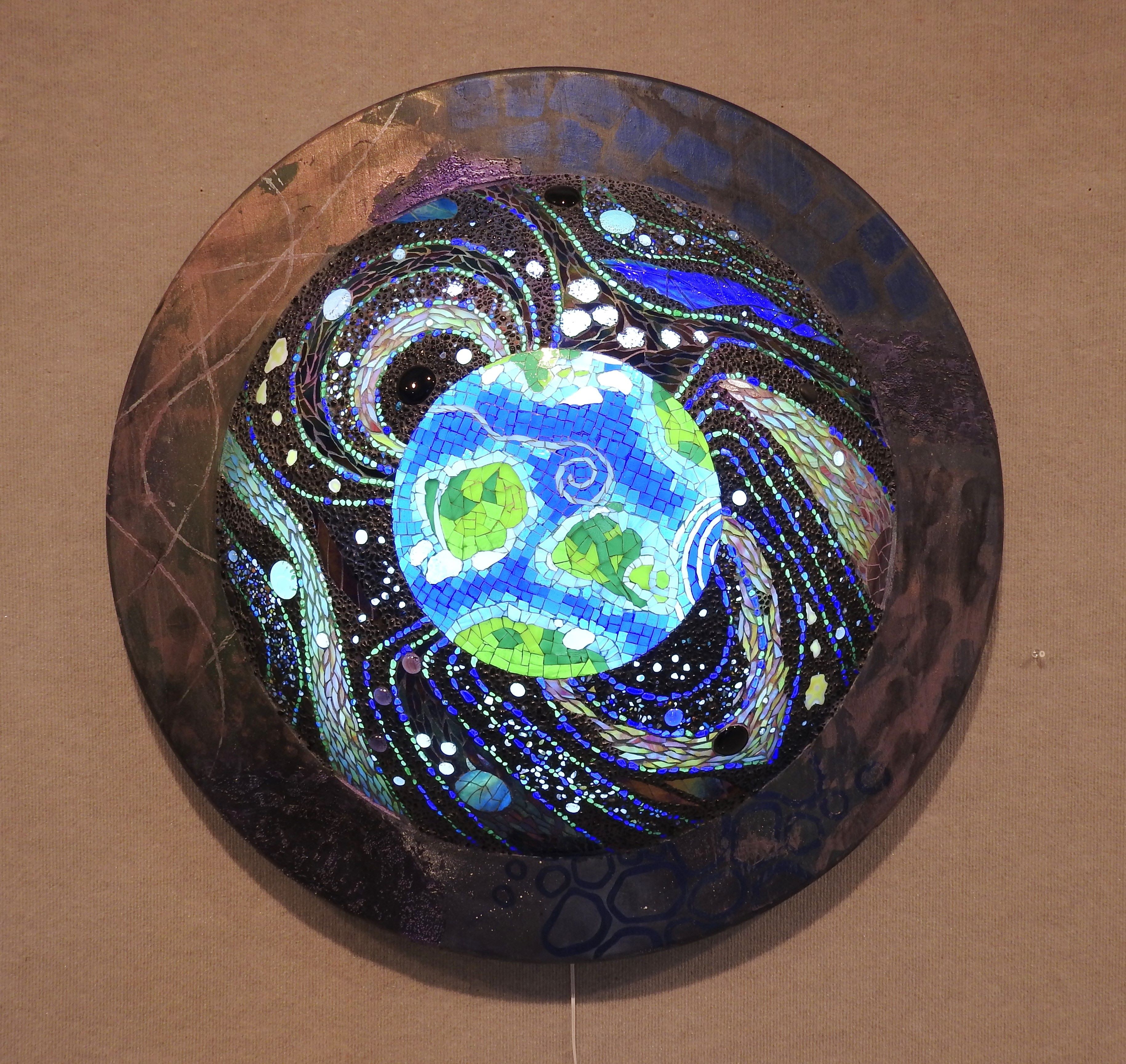 Circular artwork depicting Earth with swirling patterns and stars, surrounded by a dark border, on a beige background.