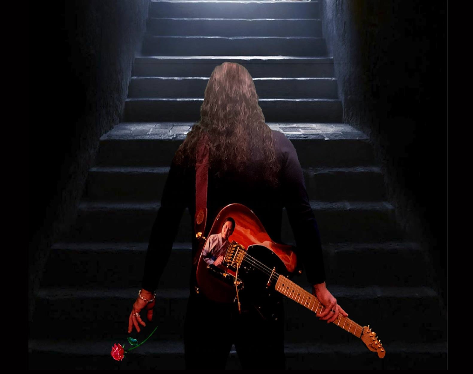 Person with long hair holding a guitar, standing at the bottom of stairs with light shining from above.
