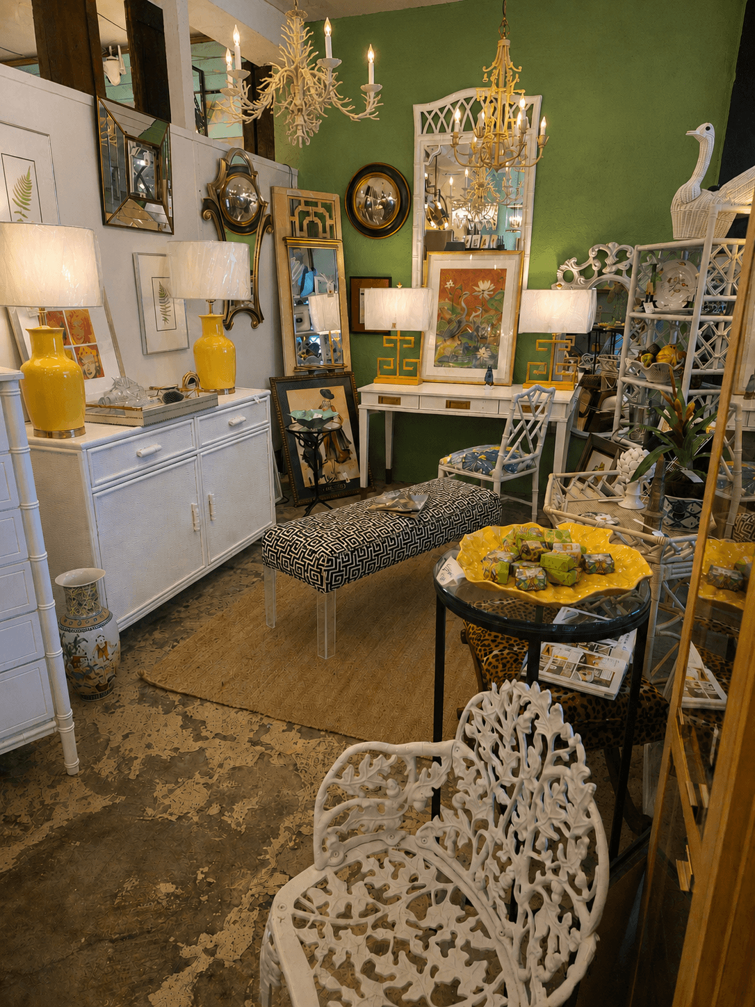 Room filled with vintage furniture, mirrors, lamps, and decorative items, including a white swan sculpture and a green wall.