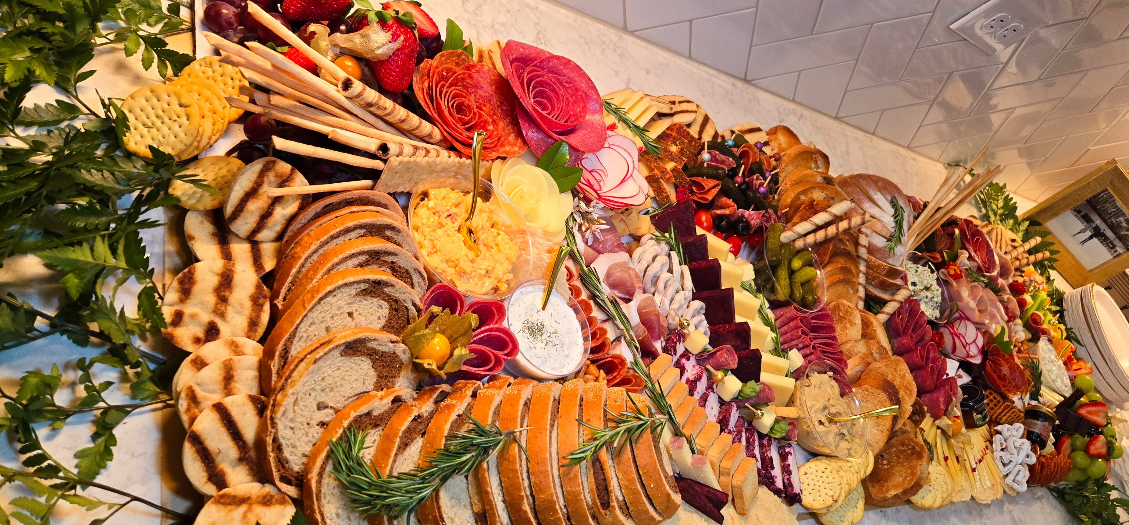 Assorted baked goods and colorful flowers arranged on a table, including bread, pastries, and decorative flowers.