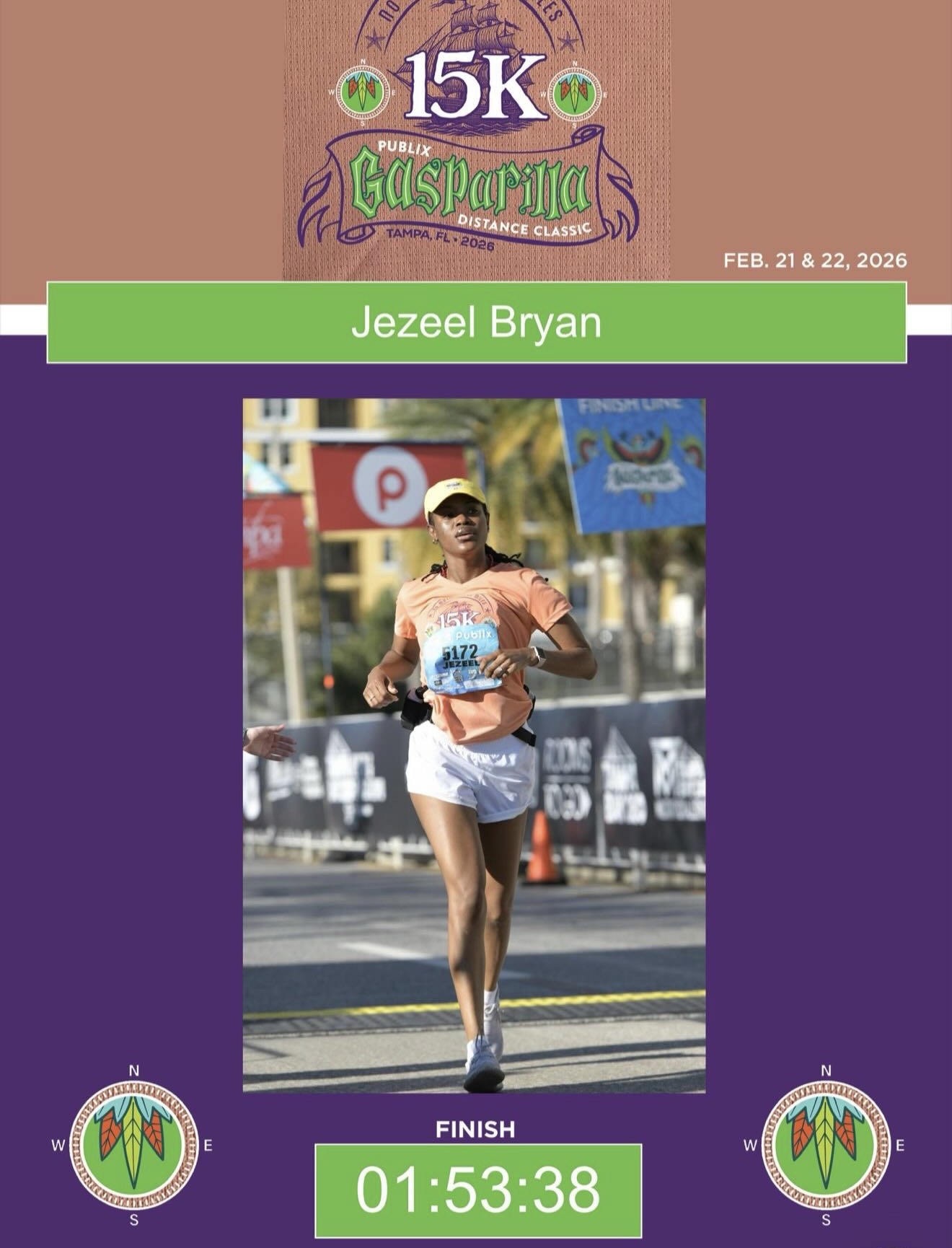 Female runner in orange shirt and white shorts crossing finish line at a race event, holding a blue cap, with race banners in background.