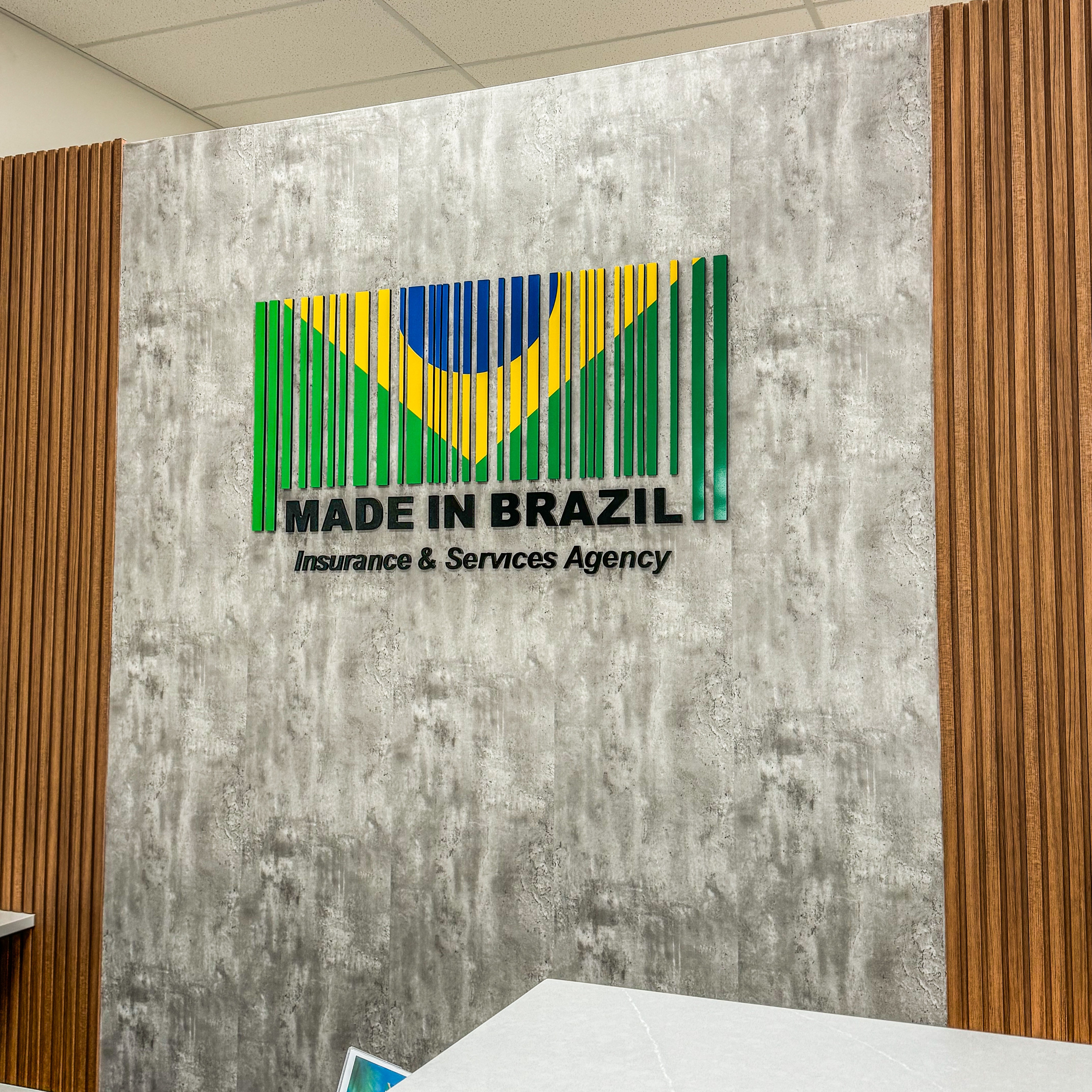 Wall with logo of Brazil flag and text 'MADE IN BRAZIL Insurance & Services Agency'.